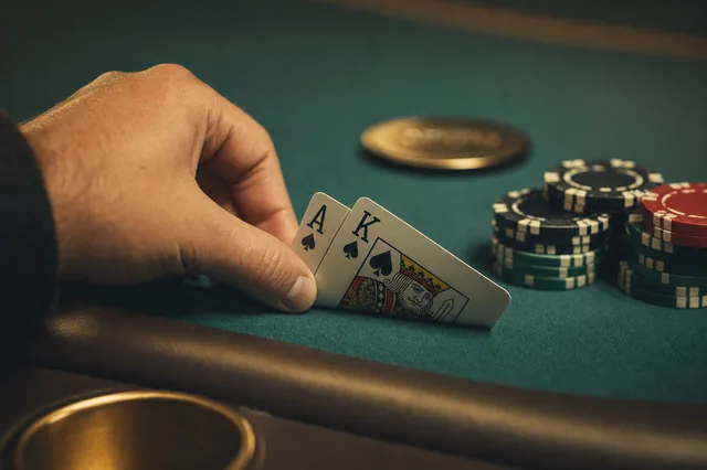Hole Cards Ass und König Pik werden am Pokertisch verdeckt geprüft — Sinnbild für die Entscheidungssituation bei No-Limit Hold'em